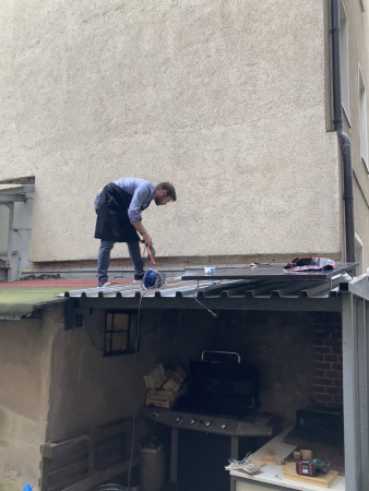Ein Mensch baut Solarpanele auf das Dach