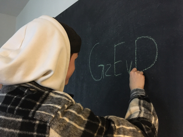 Julian schreibt die Buchstaben ‘GzEvD’ an die Tafel im Büro.